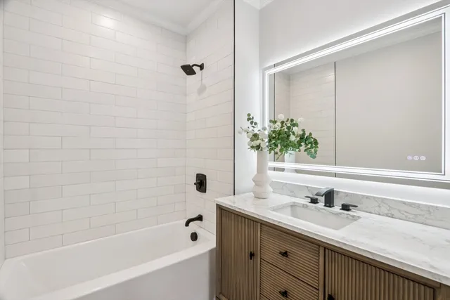 a bathroom with a granite countertop sink and a bathtub