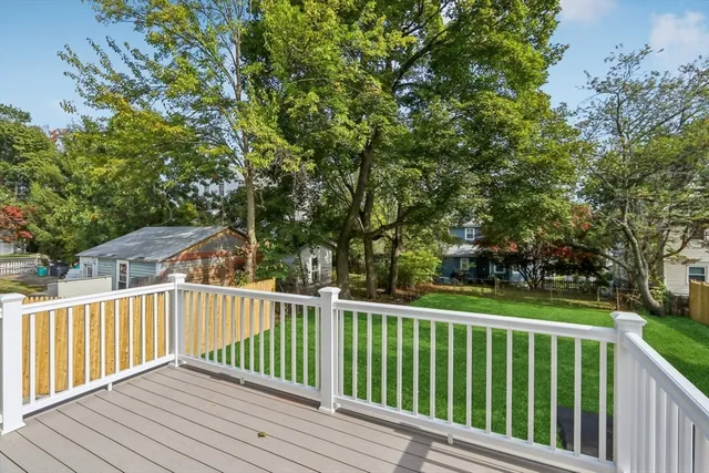 a view of a backyard with large trees and wooden fence