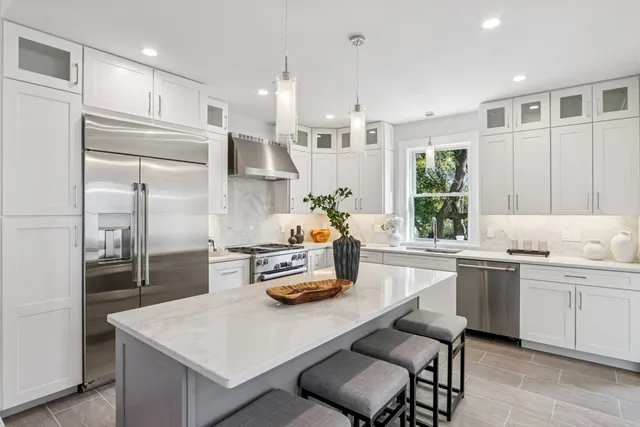 a kitchen with white cabinets and stainless steel appliances