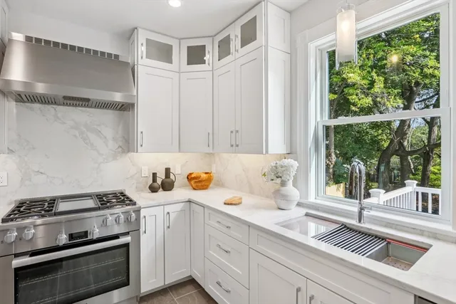 a kitchen with stainless steel appliances white cabinets and a window