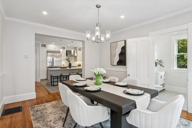 a dining room with furniture a chandelier and wooden floor
