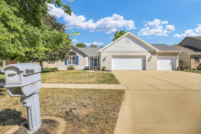 a view of an house with backyard and bushes