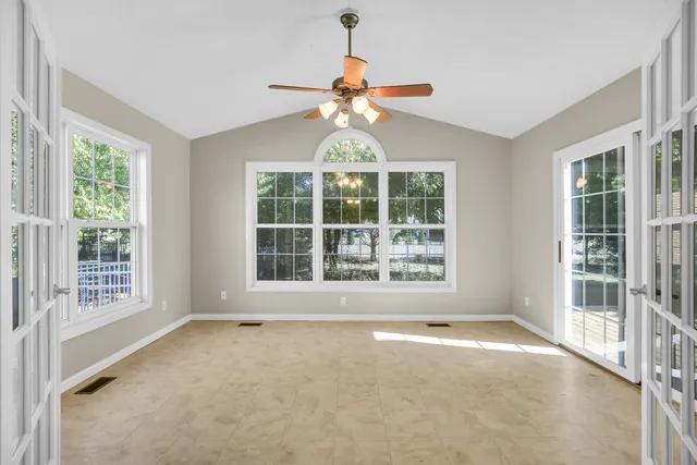 an empty room with windows and fan