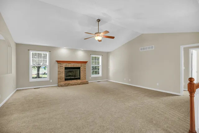 a view of an empty room with window and fireplace