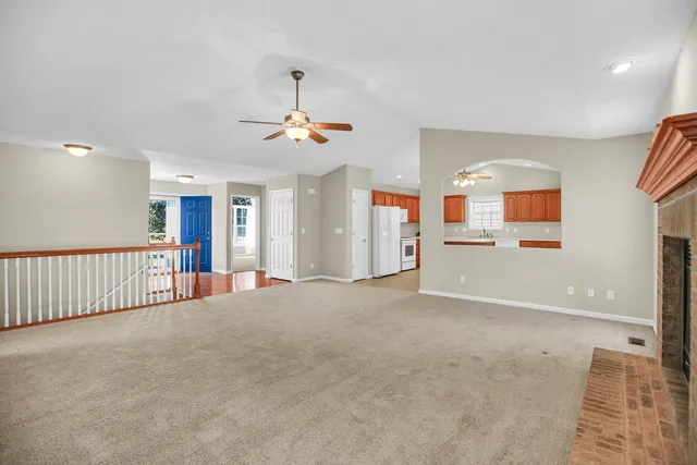 a large kitchen with a large counter top a sink stainless steel appliances and cabinets