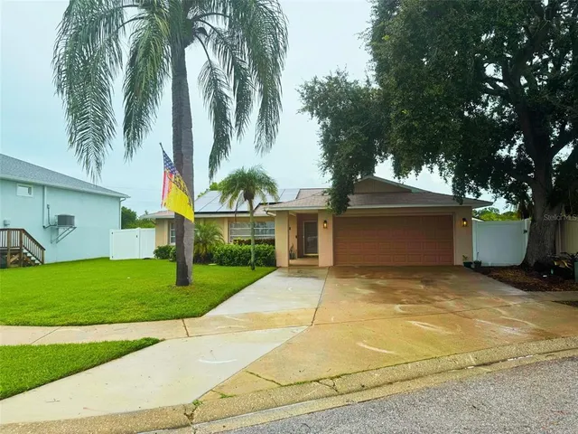 a view of a house with a yard and palm trees