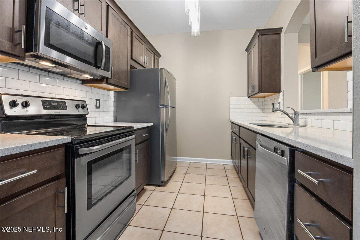 10550 Baymeadows Road, Unit 807 Jacksonville, FL 32256 - Photo 3 of 22 a kitchen with stainless steel appliances granite countertop a sink stove and microwave