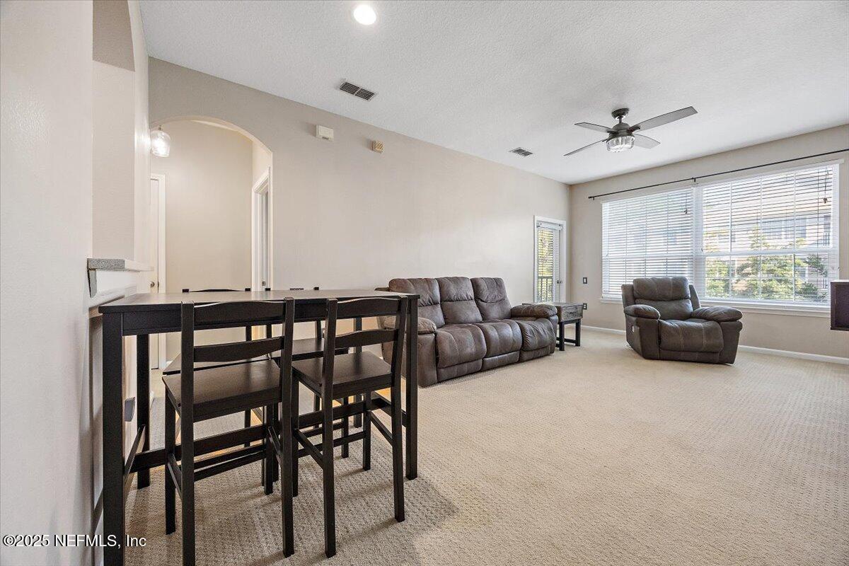 10550 Baymeadows Road, Unit 807 Jacksonville, FL 32256 - Photo 4 of 22 a living room with furniture a fireplace and a flat screen tv
