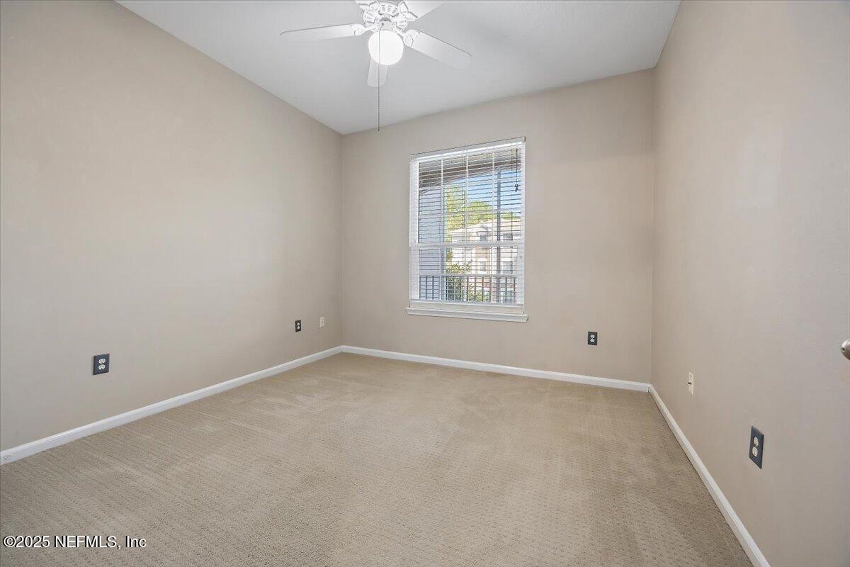 10550 Baymeadows Road, Unit 807 Jacksonville, FL 32256 - Photo 10 of 22 an empty room with a chandelier fan and windows