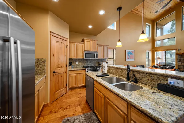 a kitchen with kitchen island granite countertop a sink stove and refrigerator
