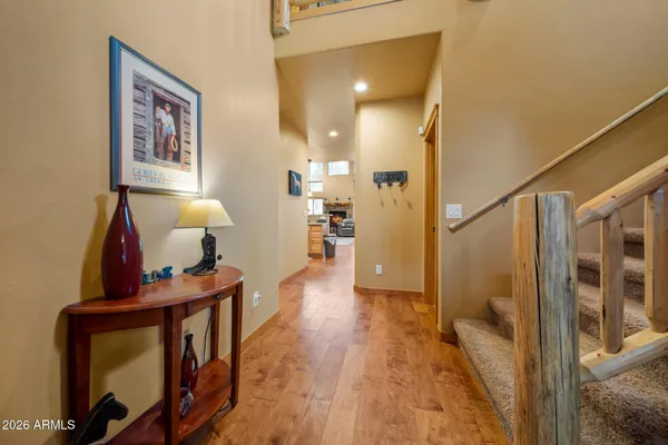 a view of a hallway with wooden floor and furniture