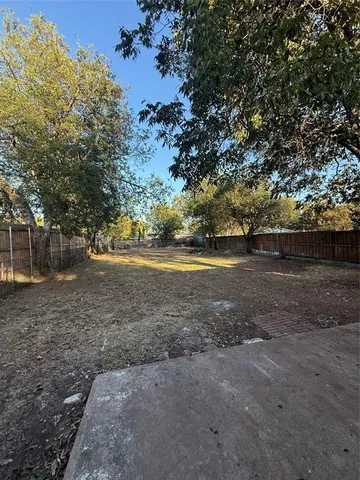a view of dirt yard with a large tree