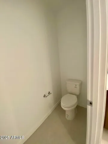 a white toilet sitting next to a white wall