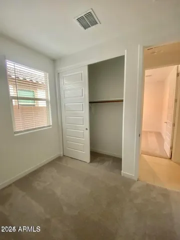 an empty room with closet and mirror