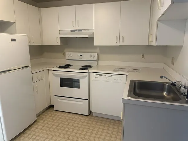 a kitchen with cabinets appliances and a sink