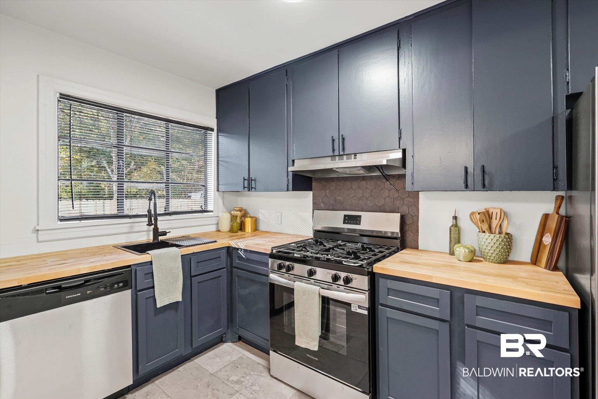 2806 Exter Drive Mobile, AL 36606 - Photo 8 of 24 Kitchen with wood counters, appliances with stainless steel finishes, tasteful backsplash, and under cabinet range hood