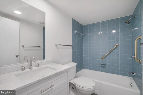 a bathroom with a toilet a sink a mirror a bathtub and shower
