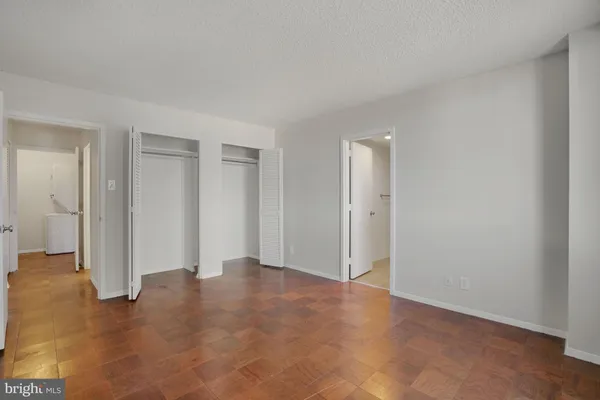 an empty room with windows and closet