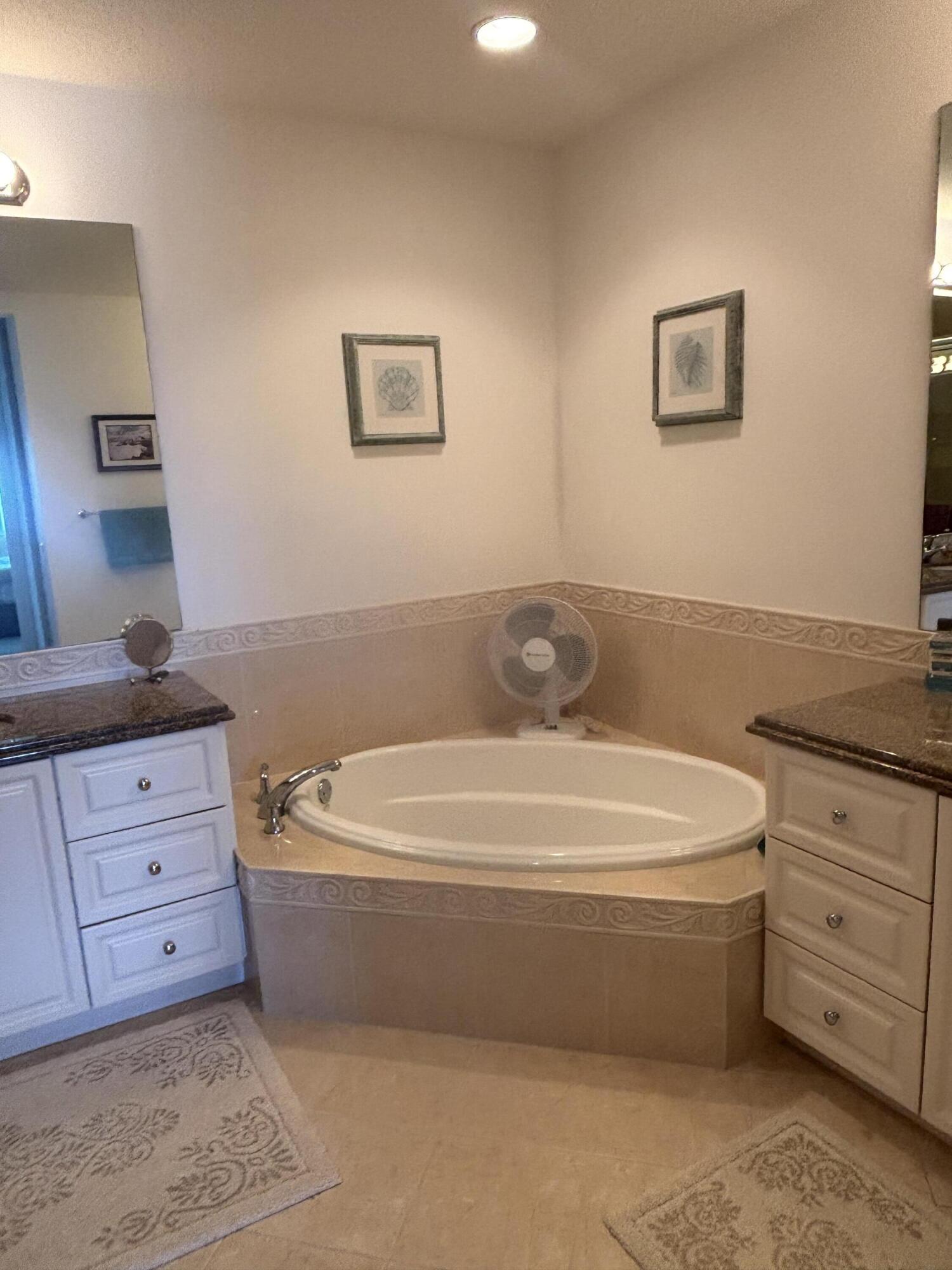 15 Harbour Isle Drive West, Unit PH 5 Fort Pierce, FL 34949 - Photo 13 of 20 a spacious bathroom with a tub sink and mirror