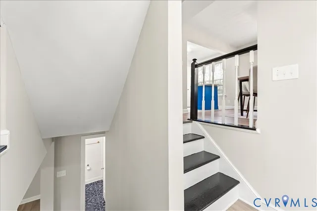 a view of staircase with railing and a window