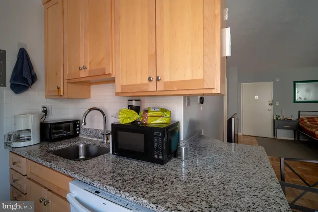 a kitchen with stainless steel appliances granite countertop a sink a stove and cabinets
