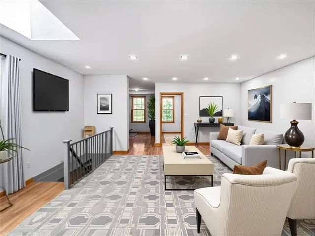 a living room with furniture a flat screen tv and a refrigerator