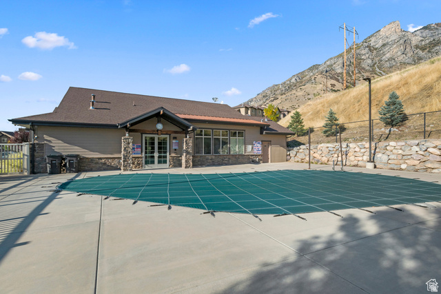 1614 Aspen Loop Provo, UT 84606 - Photo 47 of 47 Community pool area featuring a covered pool, concrete decking, and an adjacent clubhouse with stone and siding exterior