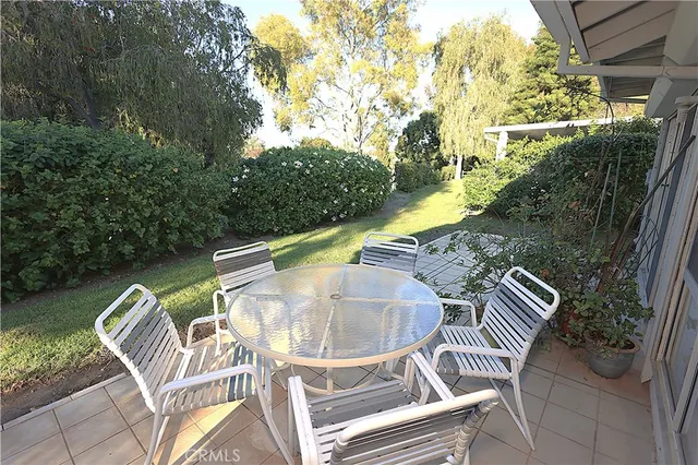 a view of swimming pool with chairs and wooden fence