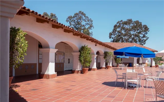 a patio with a table and chairs under an umbrella