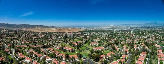 a view of a city with lush green forest
