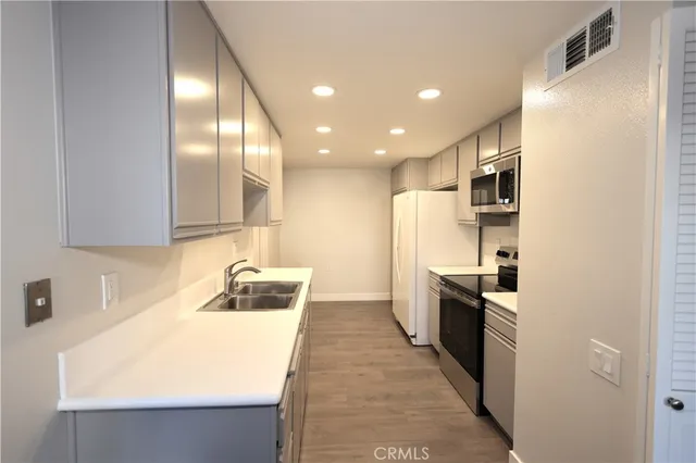 a kitchen with stainless steel appliances a refrigerator sink and stove