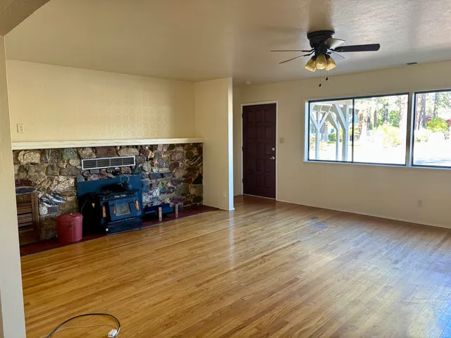 wooden floor with ceiling fan and window