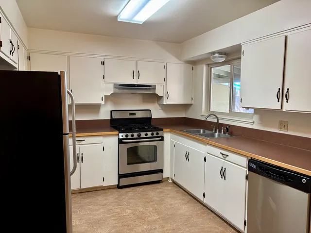 a kitchen with stainless steel appliances a sink stove and refrigerator