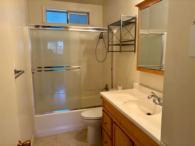 a bathroom with a granite countertop sink toilet and shower