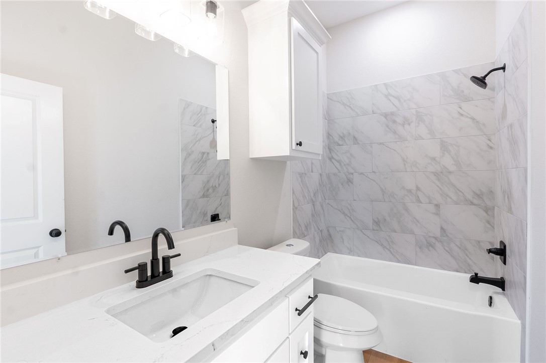 497 Combine Road Snook, TX 77879 - Photo 14 of 27 a bathroom with a sink a toilet and a bathtub