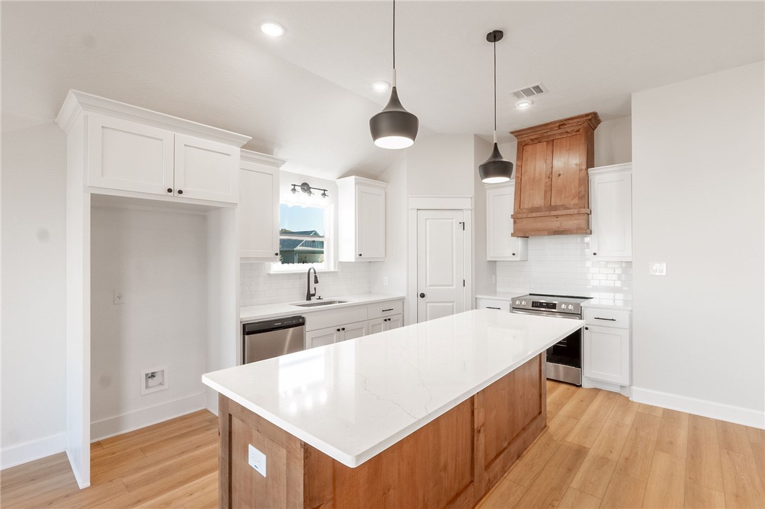 497 Combine Road Snook, TX 77879 - Photo 5 of 27 a kitchen with a sink a stove a refrigerator and white cabinets