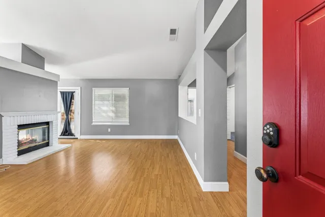 an empty room with windows and fireplace