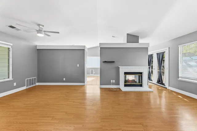a view of an empty room with a fireplace and a window