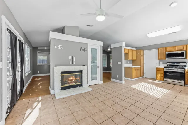 a view of a livingroom with a fireplace cabinet and windows