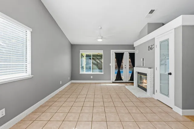 a view of an empty room with a fireplace and a window