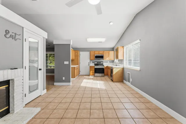 a large white kitchen with white cabinets and stainless steel appliances