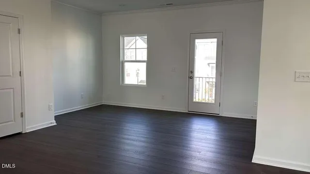 an empty room with wooden floor and window