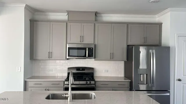 a kitchen with white cabinets and stainless steel appliances