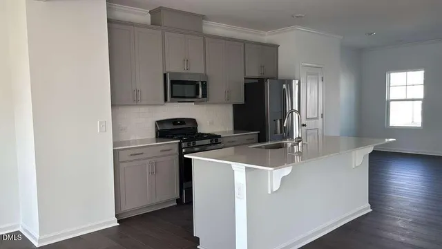 a kitchen with stainless steel appliances white cabinets and a refrigerator