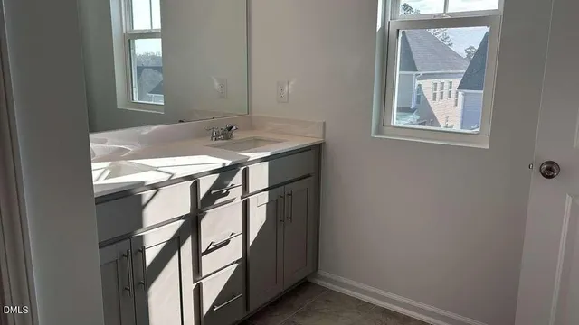 a bathroom with a sink mirror and a window