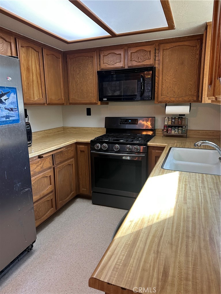 15609 Spunky Canyon Road Green Valley, CA 91390 - Photo 8 of 29 a kitchen with wooden cabinets a sink and a stove