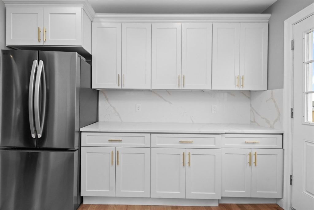 66 Stanley Street Boston, MA 02125 - Photo 11 of 42 a kitchen with white cabinets and refrigerator