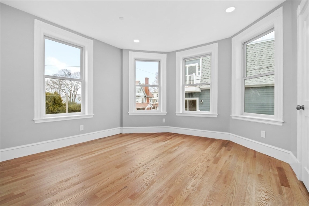 66 Stanley Street Boston, MA 02125 - Photo 17 of 42 a view of an empty room with wooden floor and a window