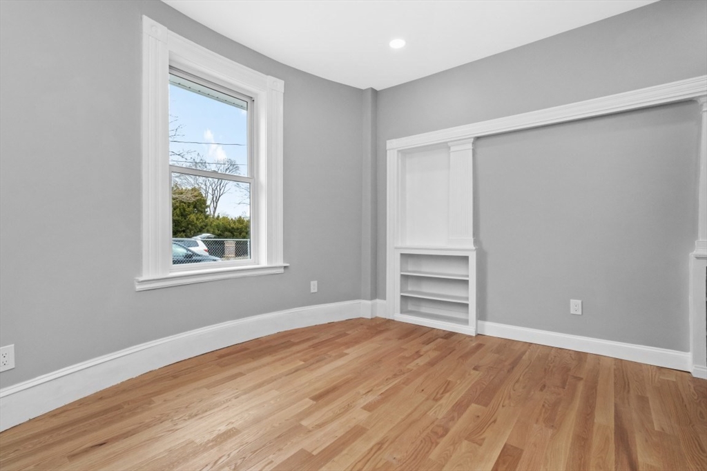 66 Stanley Street Boston, MA 02125 - Photo 18 of 42 an empty room with wooden floor closet and windows