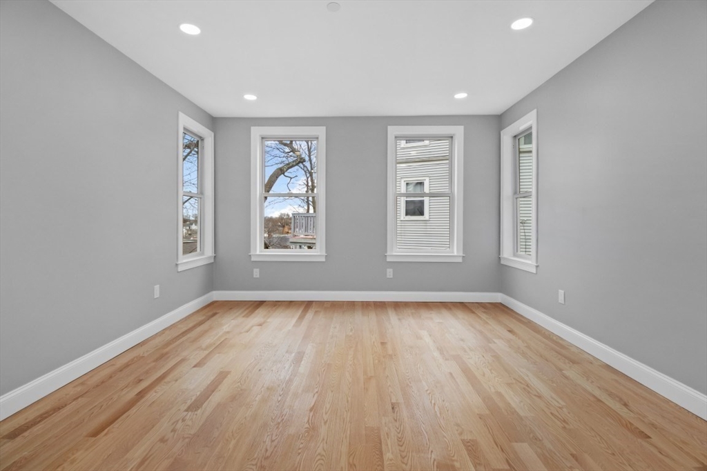 66 Stanley Street Boston, MA 02125 - Photo 21 of 42 a view of an empty room with wooden floor and window